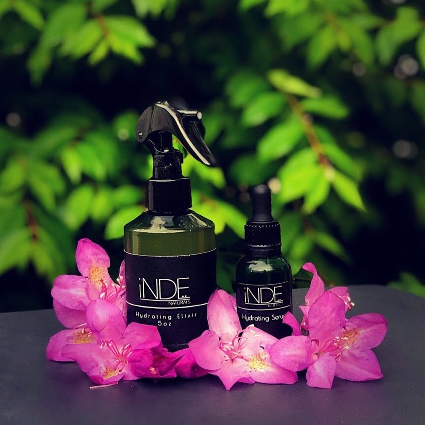 Inde Naturals grooming products styled with flowers and greenery