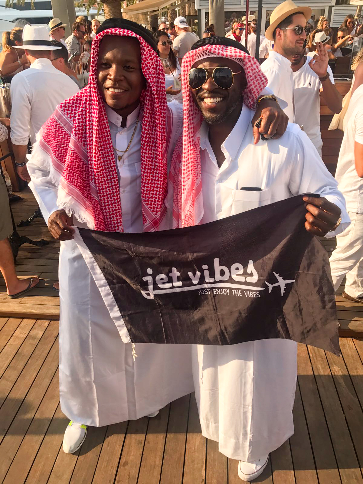 Jet Vibes founders Jeremiah Ransaw and Jet Wright holding the brand flag in Dubai