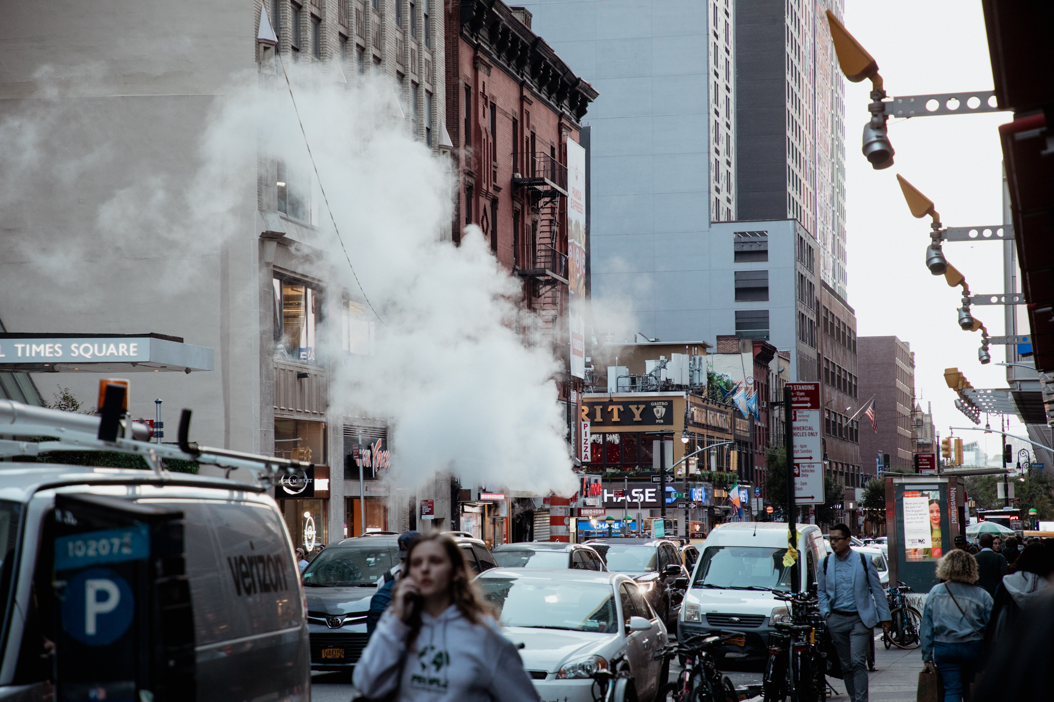 Steam rising from street in busy New York City intersection