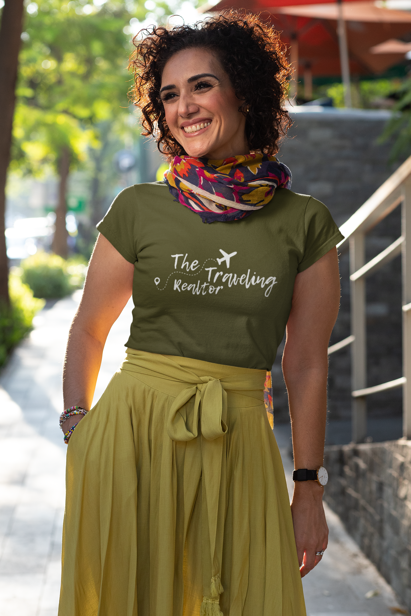 Woman walking outdoors wearing The Traveling Realtor branded t-shirt styled for everyday lifestyle use