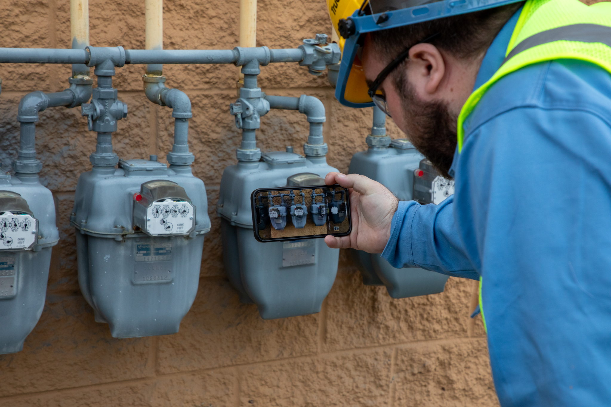 TruCheck technician documenting utility meter equipment using mobile technology in the field.
