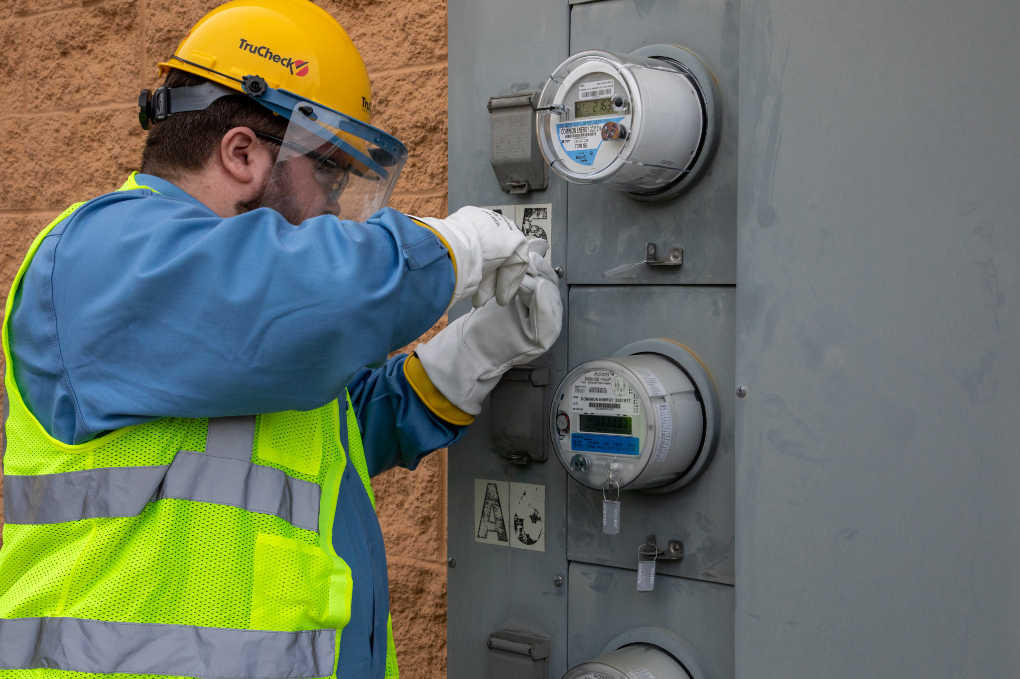 Close-up of a TruCheck technician servicing utility meter equipment during field operations.
