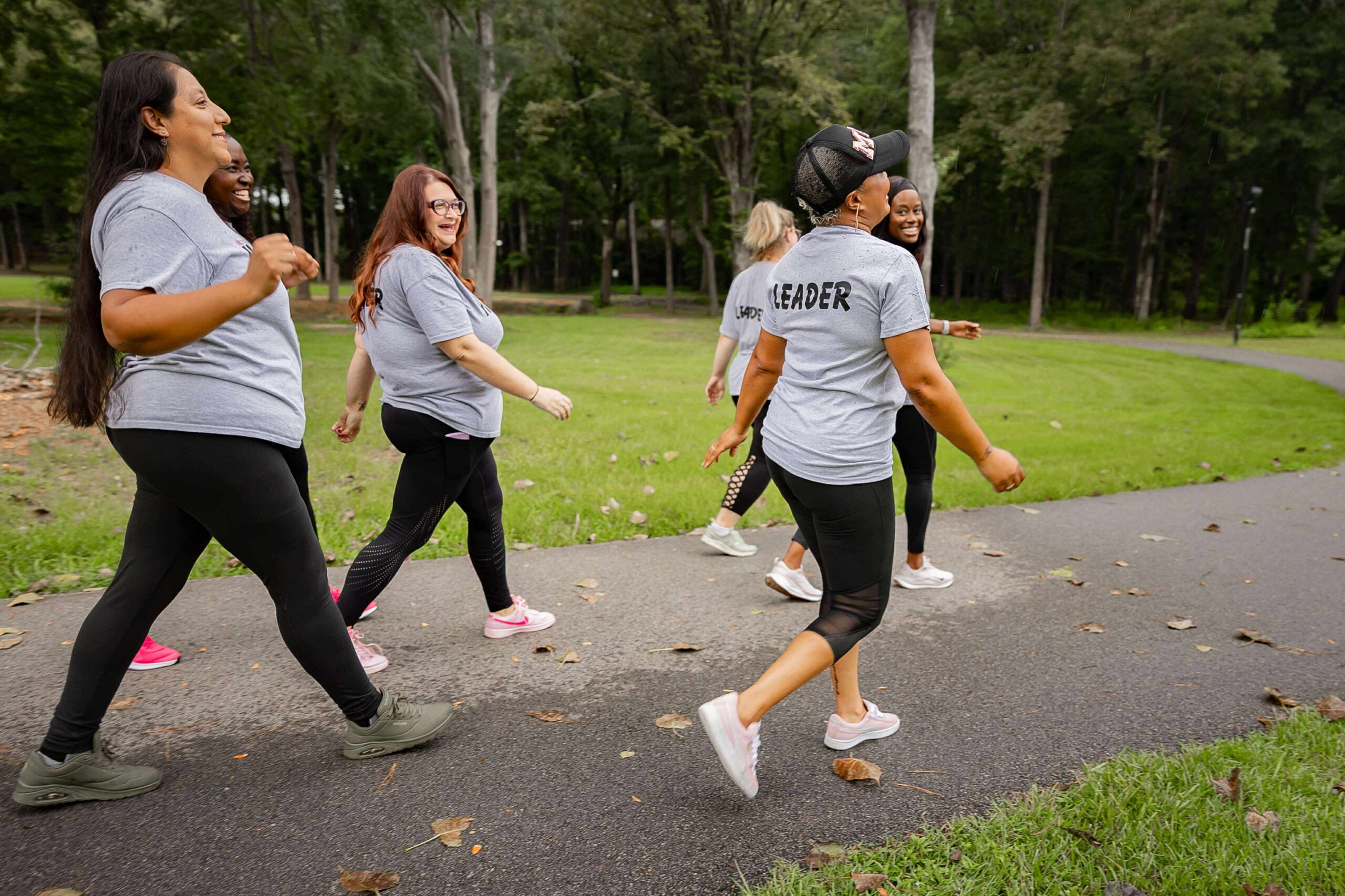 McDonough Moms MOVE walking group leaders walking together on a park trail during a branded leadership photoshoot.